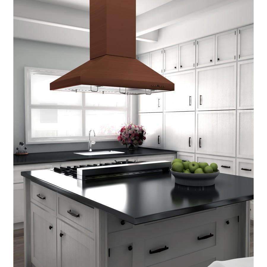 Copper island range hood above black cooktop on white cabinetry kitchen