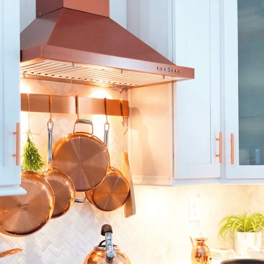 Wall-mounted copper range hood with vent panel and front control row.