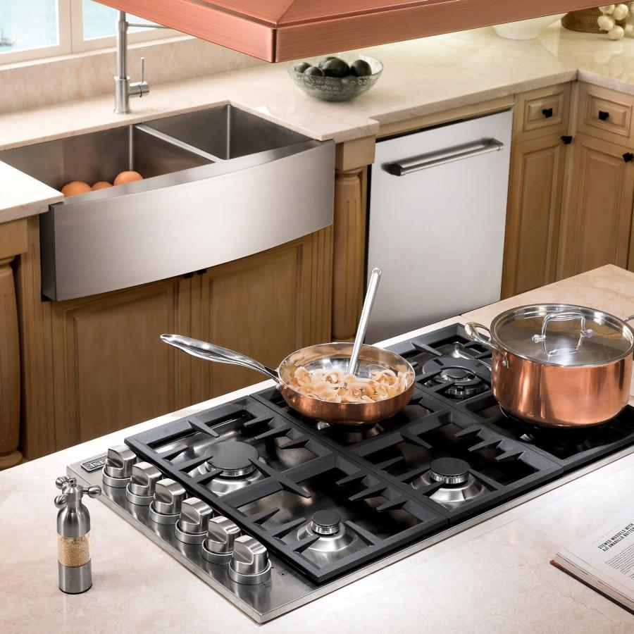 Stainless steel double-basin farmhouse sink integrated into a kitchen countertop setup.