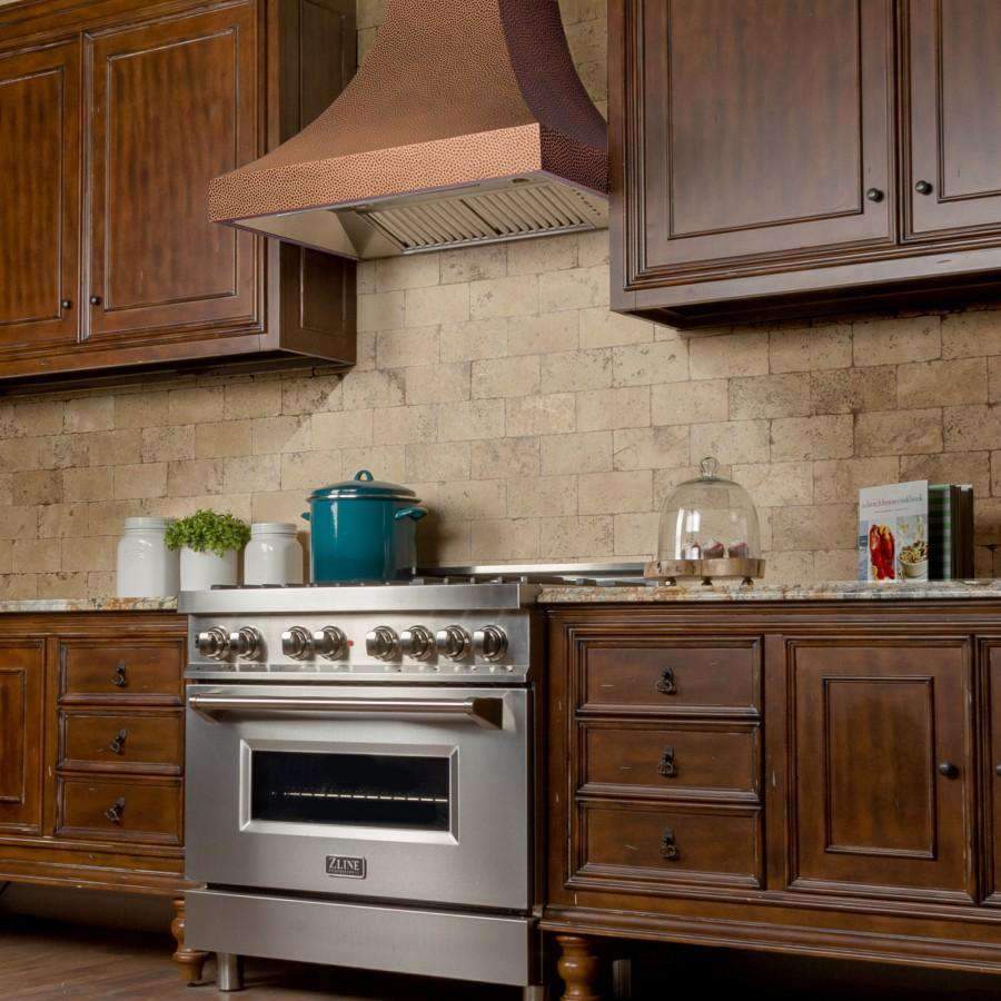 Copper hammered wall range hood with stainless vent canopy and chimney flue