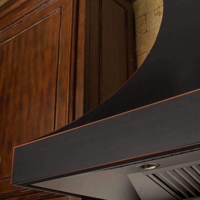 Range hood canopy underside with dark panel, round vent openings, and bronze-trim edge.