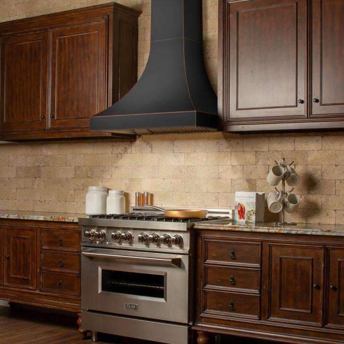 Wall-mount range hood with dark finish, bronze-trim border, curved chimney shape.