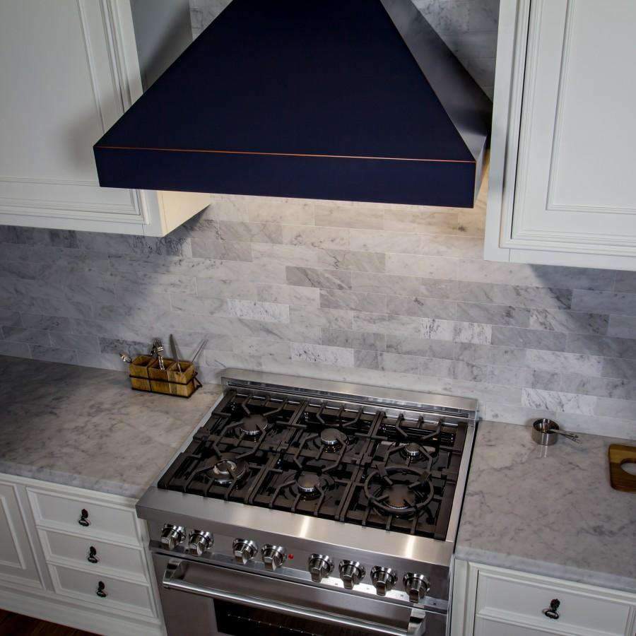 Wall-mounted range hood with dark finish and crown-molded chimney