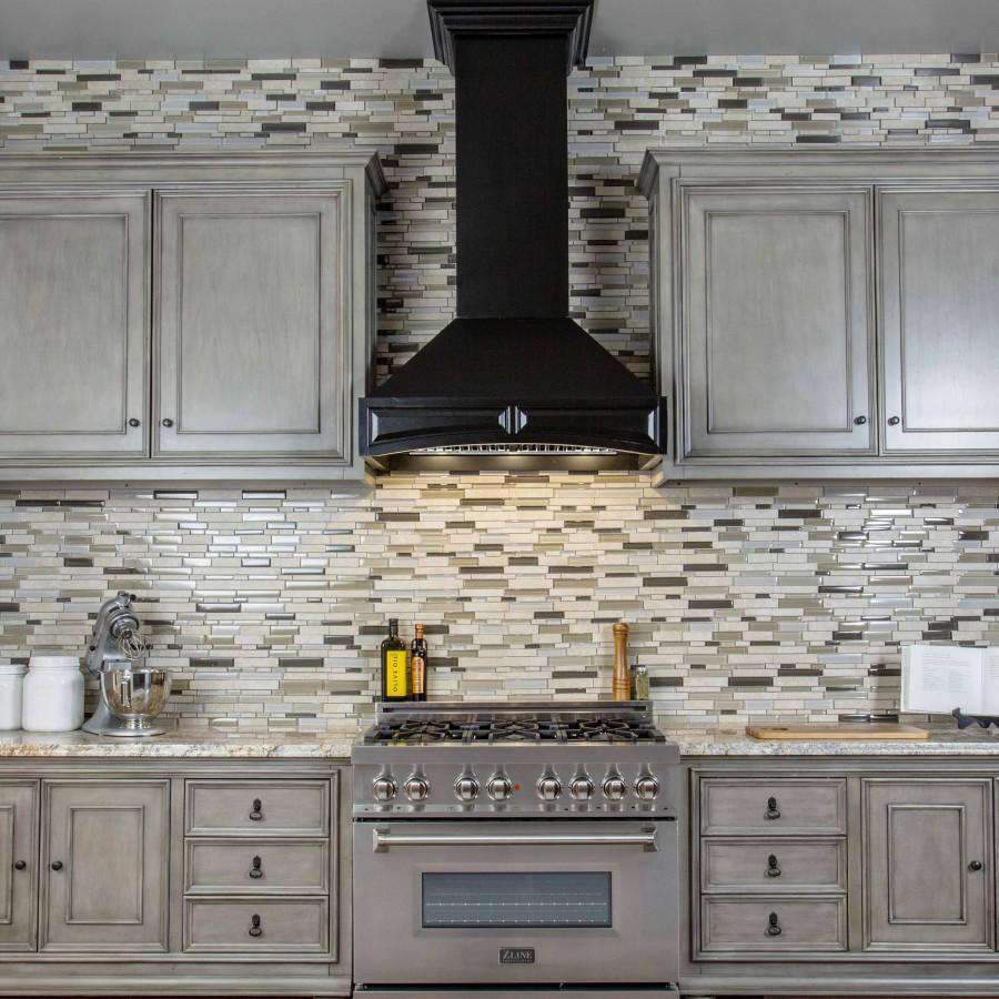 Black chimney-style wall range hood centered over a gas cooktop in a cabinetry kitchen