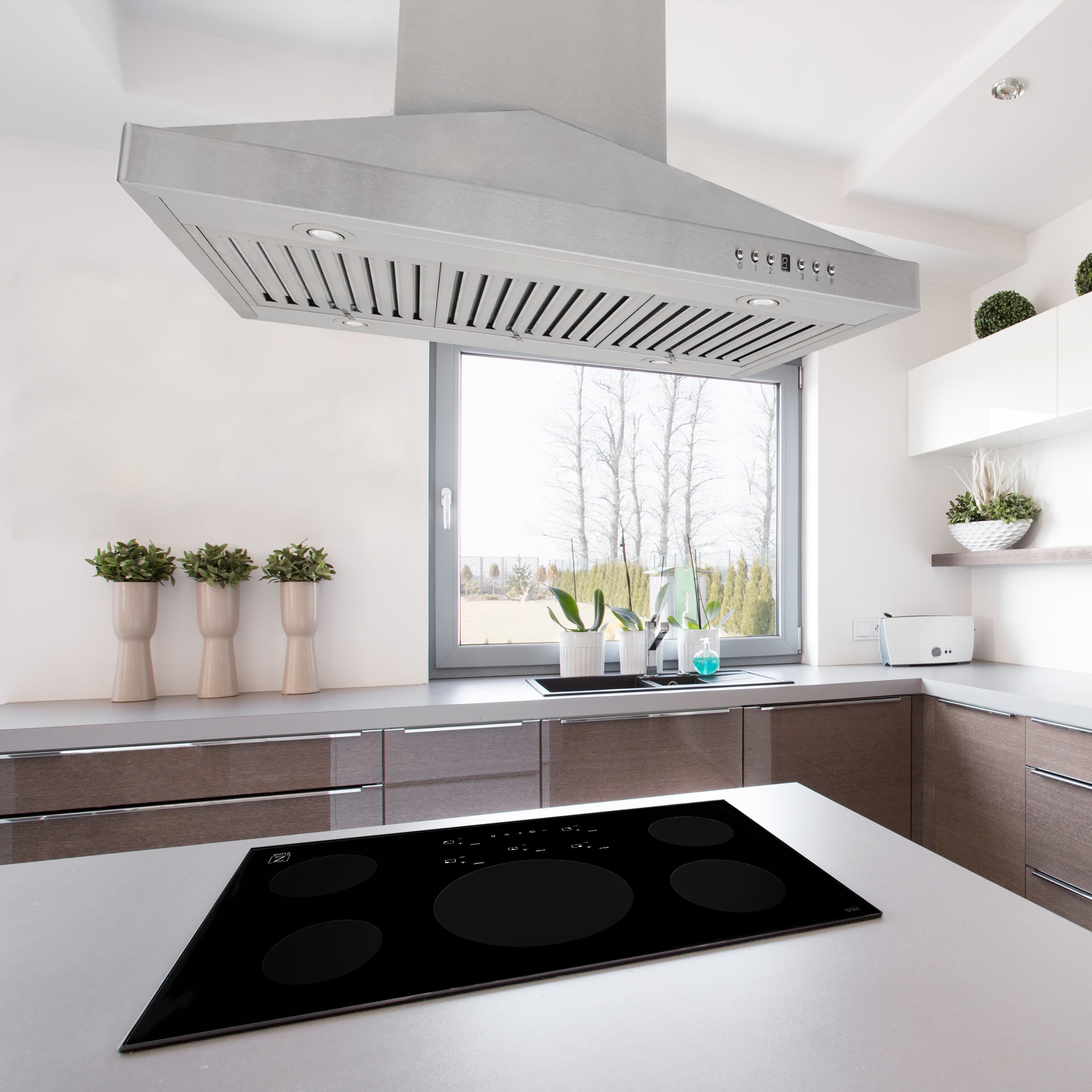 Stainless steel island range hood over black cooktop with front control panel