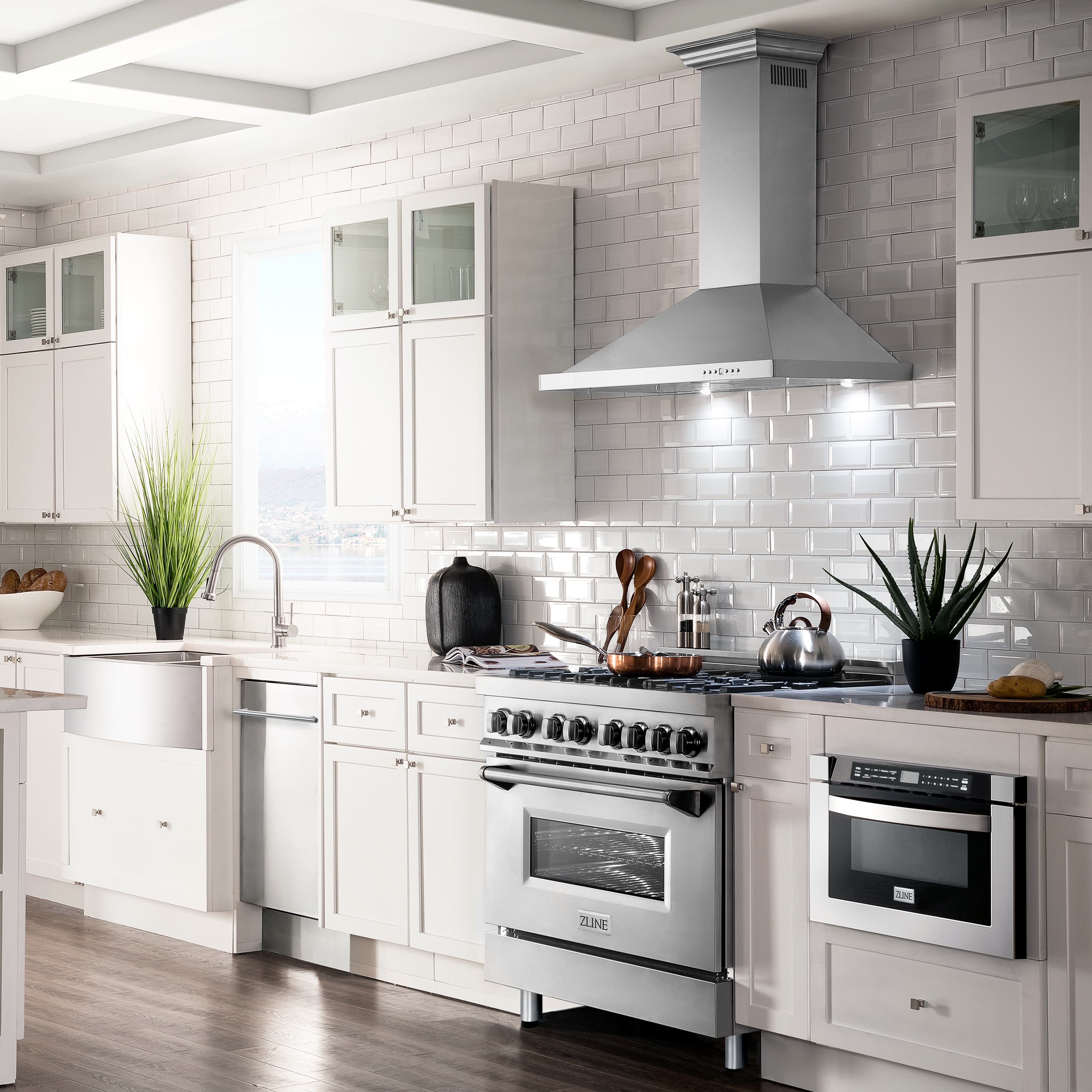 Stainless steel wall mount range hood above a cooktop in a modern kitchen