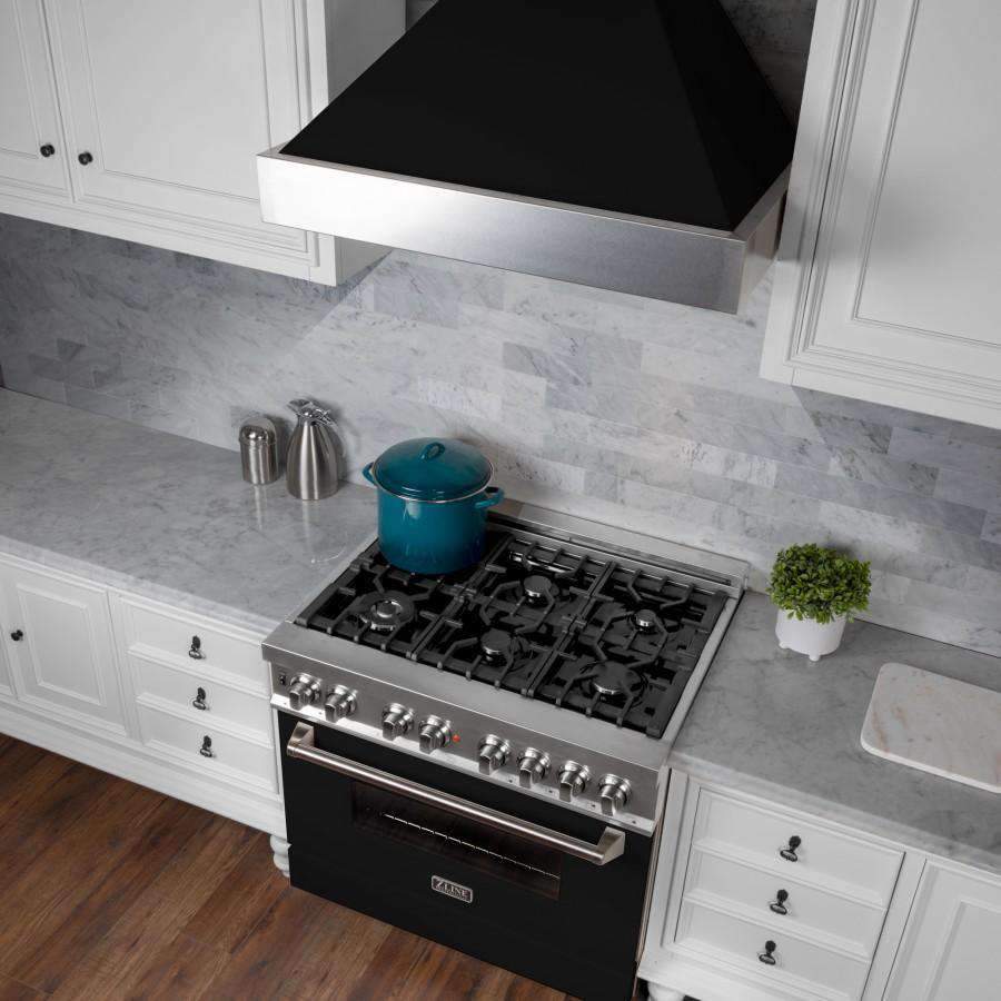 Mounted ducted range hood above gas cooktop with black matte interior baffle