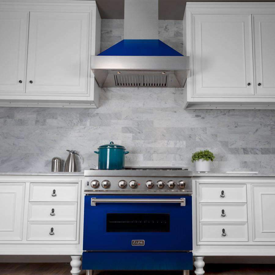 Blue glossy ducted range hood with stainless chimney over a gas cooktop