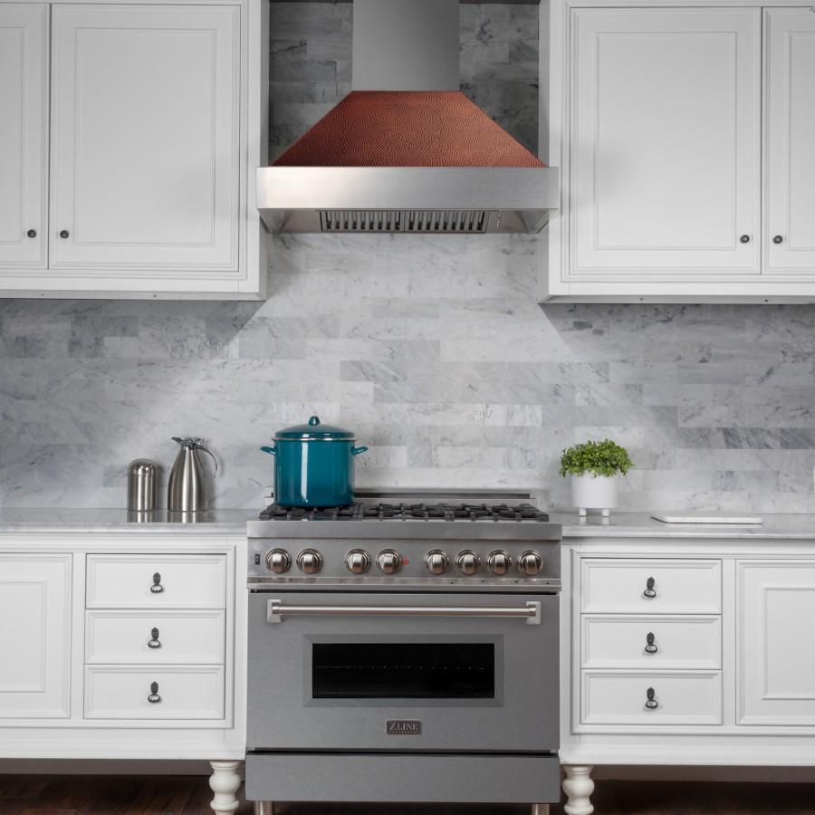Ducted wall range hood above gas range, stainless chimney with hammered copper canopy