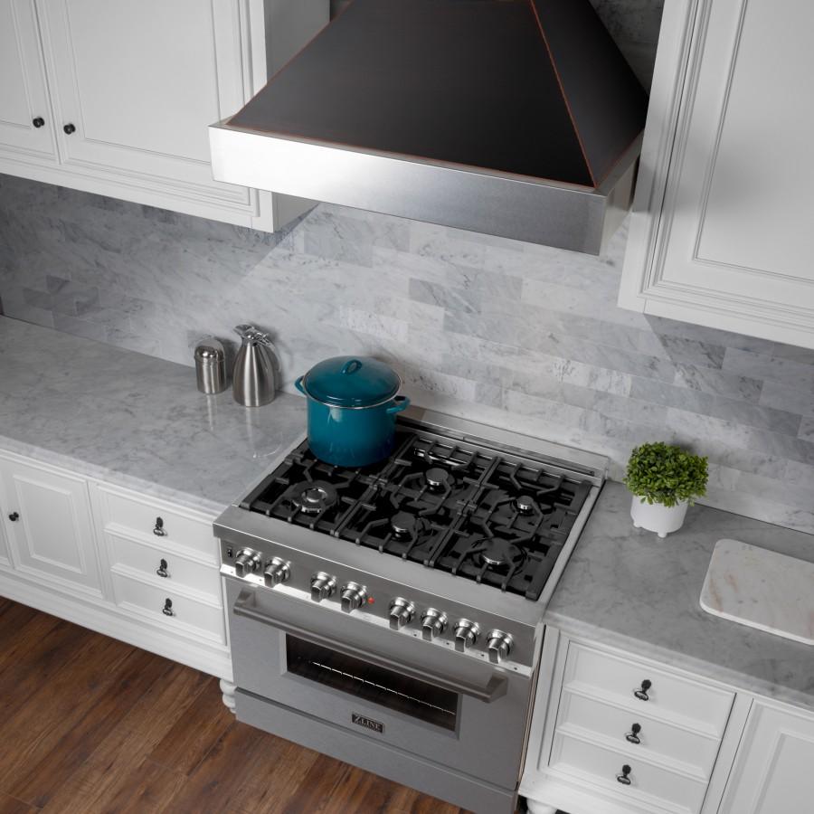 Wall mount range hood with stainless steel chimney and black canopy above cooktop