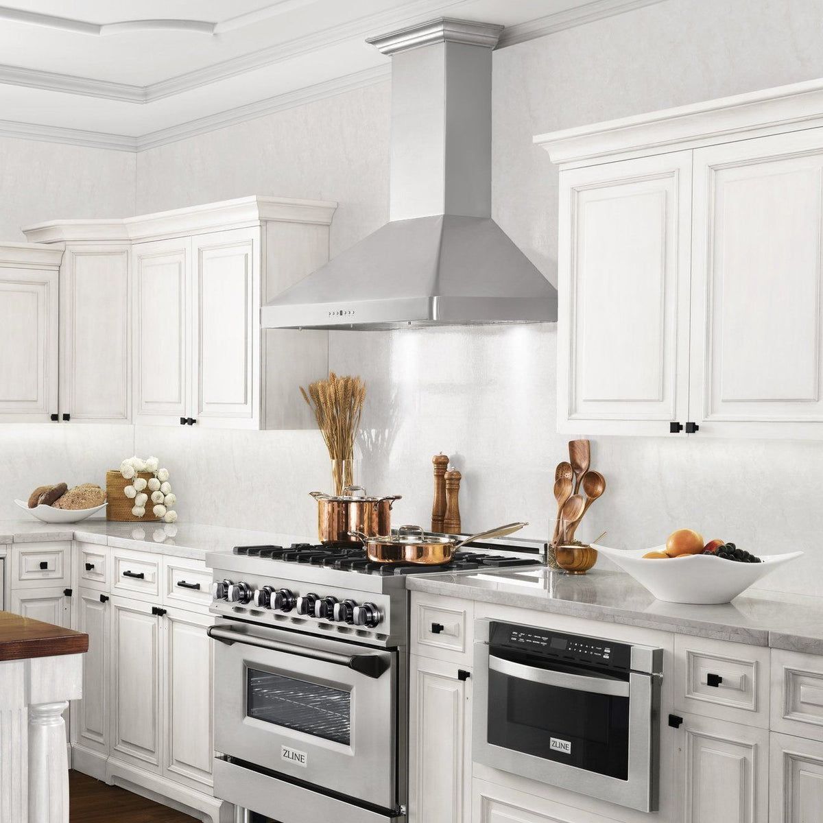 Stainless steel wall-mount range hood above the cooktop, with chimney body