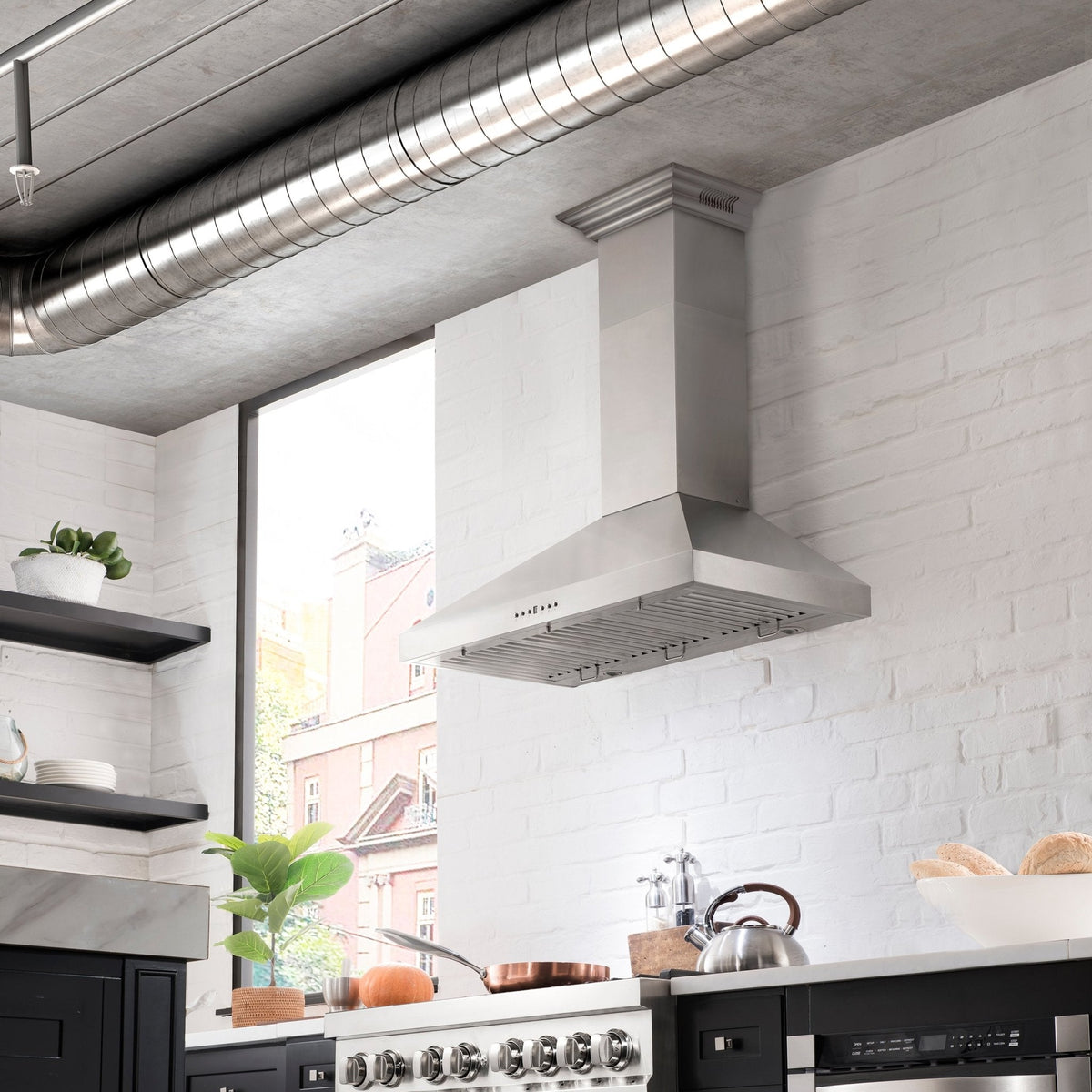 Wall-mounted stainless steel range hood over a kitchen cooktop with ducting vent.
