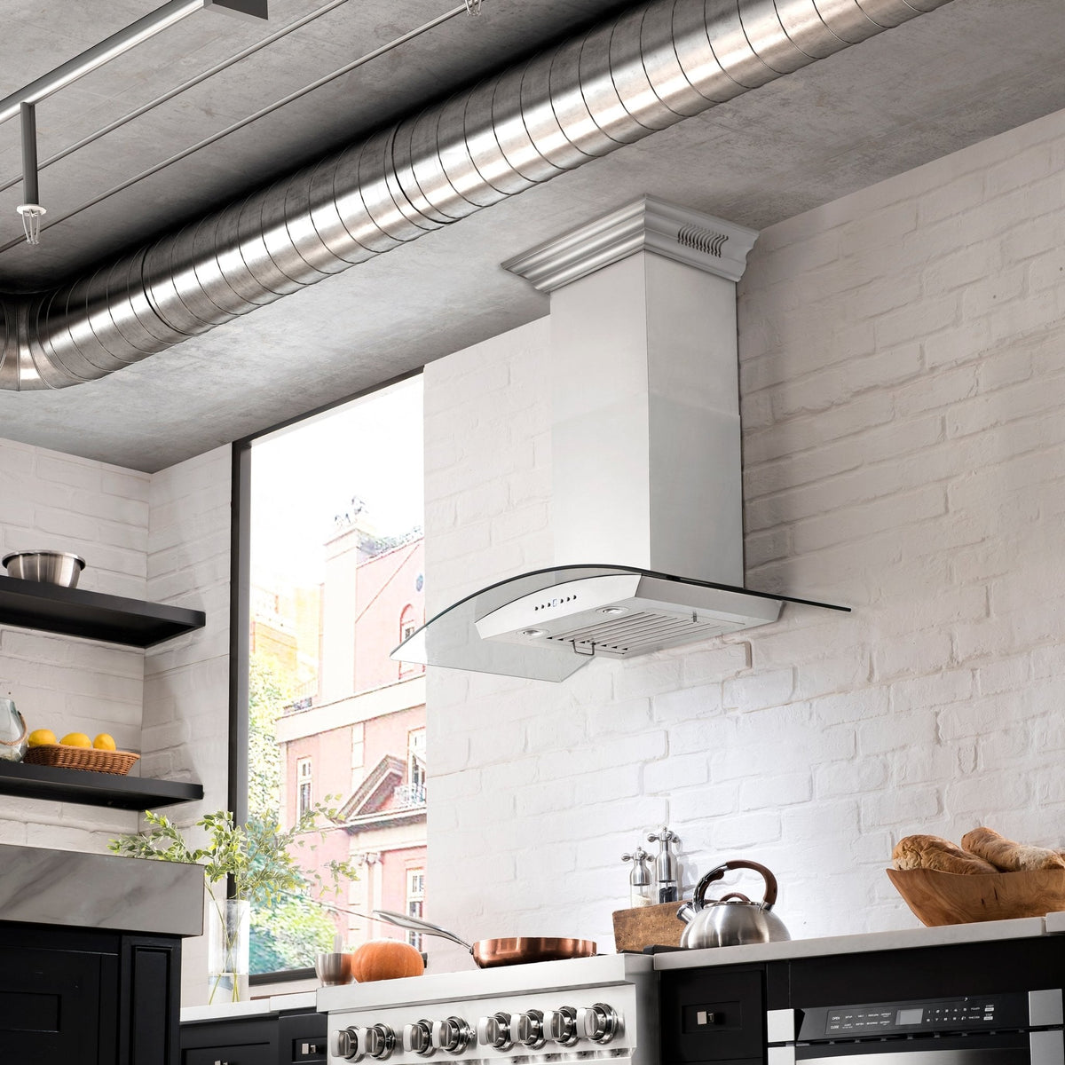 Wall-mounted stainless steel range hood chimney with curved canopy over cooktop
