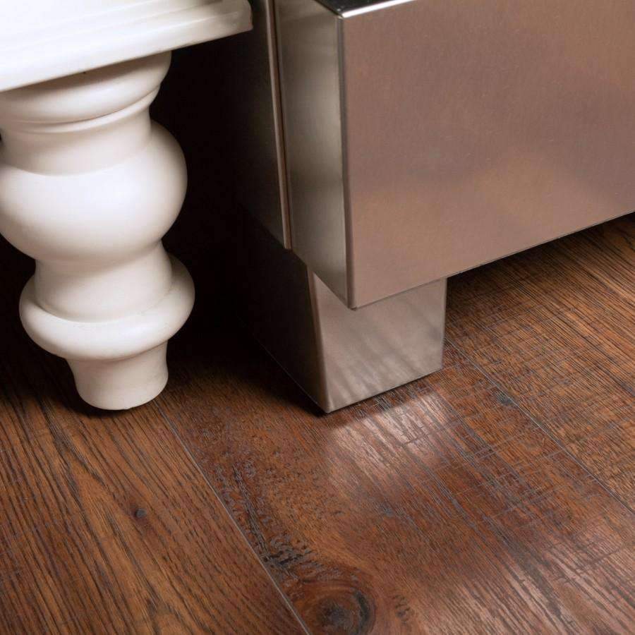 Satin stainless range base with four leveling feet on wooden floor