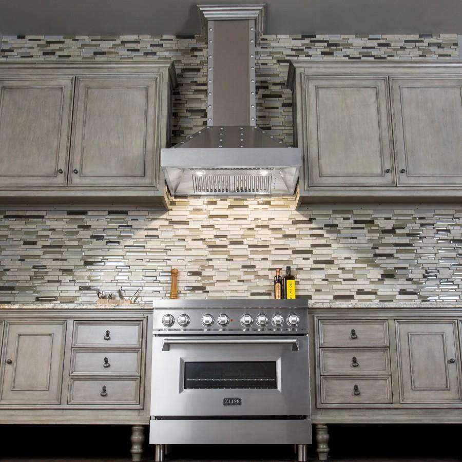 Stainless steel chimney range hood above a built-in stove, with front burner controls