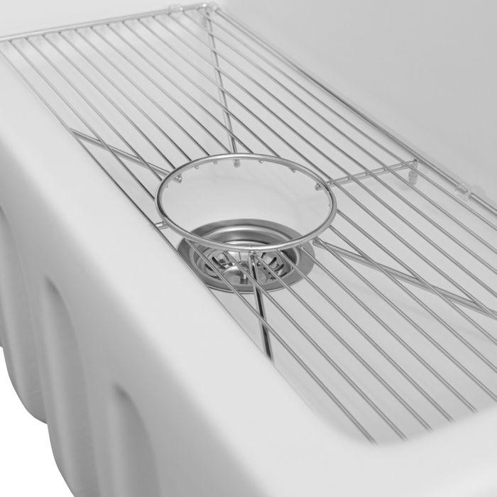 White fireclay sink with stainless bottom grid and circular drain cover
