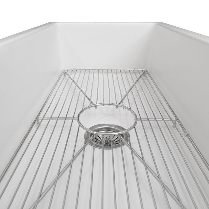White fireclay sink with stainless bottom grid and circular drain basket