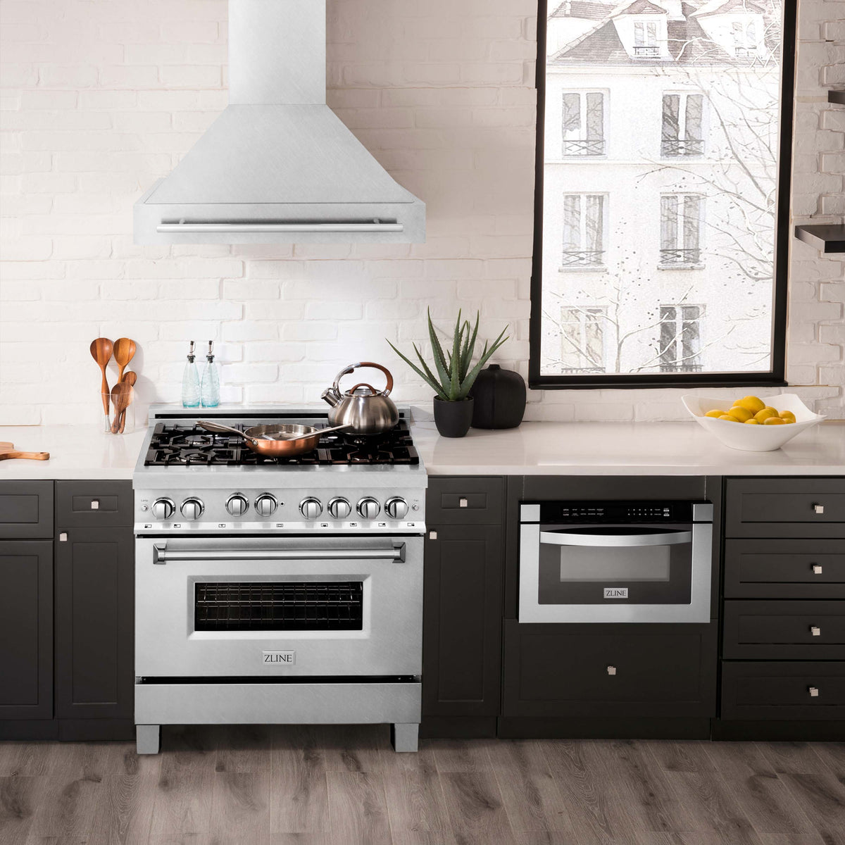 Satin stainless steel wall-mount range hood over cooktop in a modern kitchen