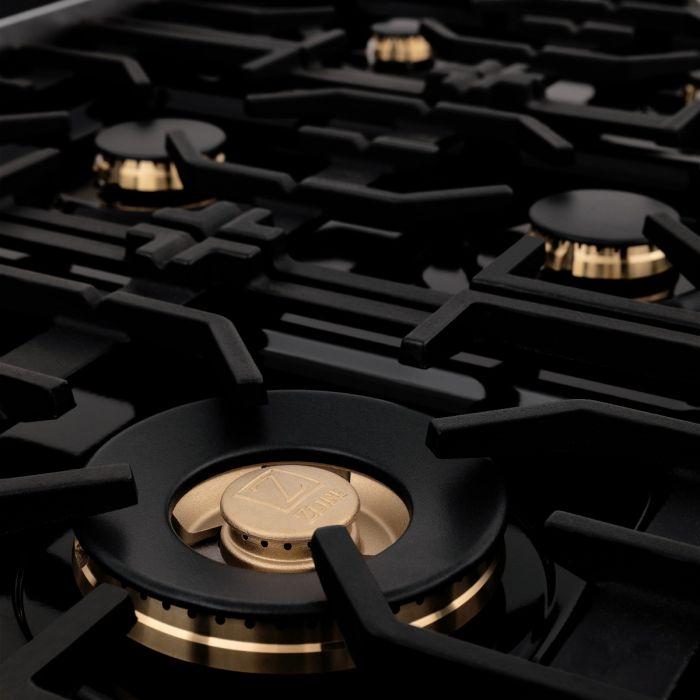 Gas cooktop burner with brass cap and black grates on a dark cooktop