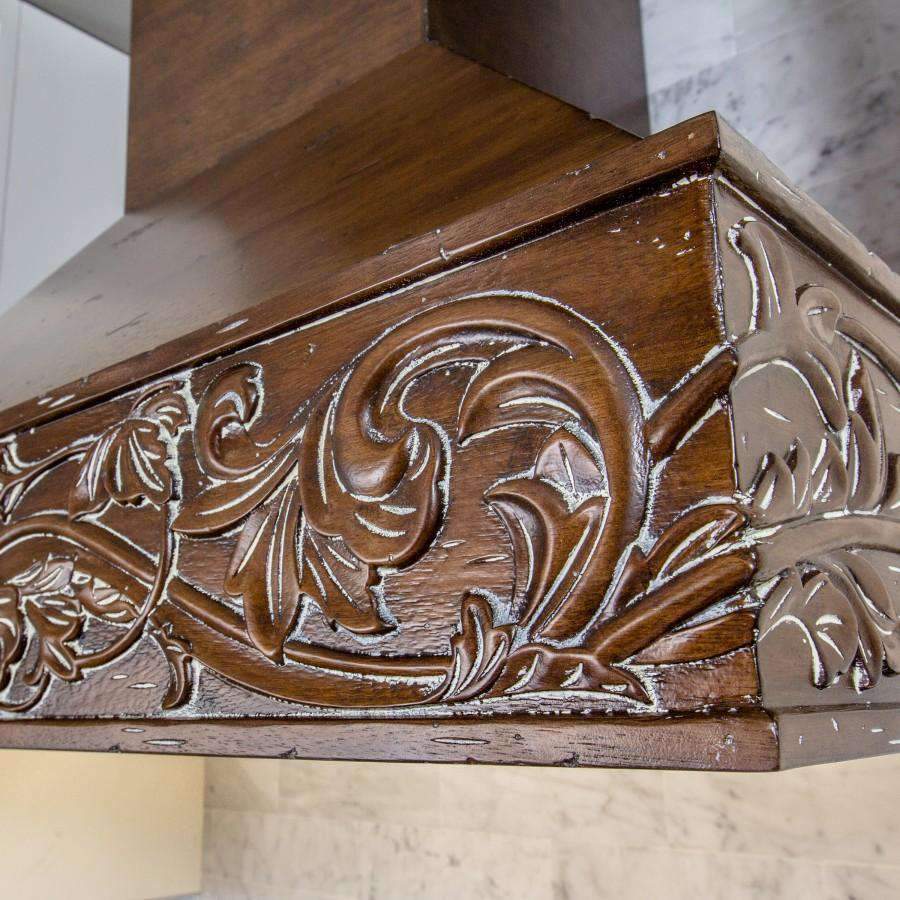 Carved wooden range hood front panel with ornate floral scrollwork