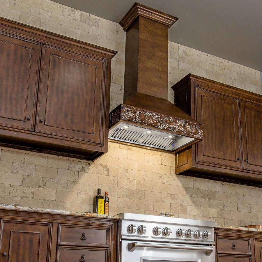 Wooden wall range hood with carved trim and stainless steel vent canopy