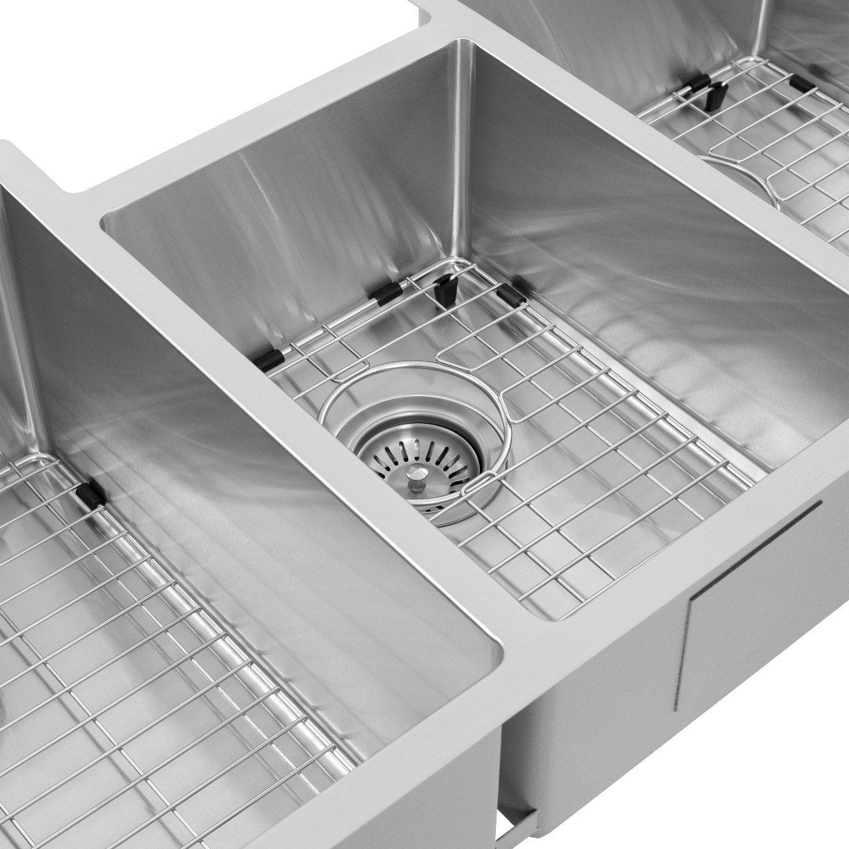 Triple bowl sink corner view with stainless bottom grid and central drain