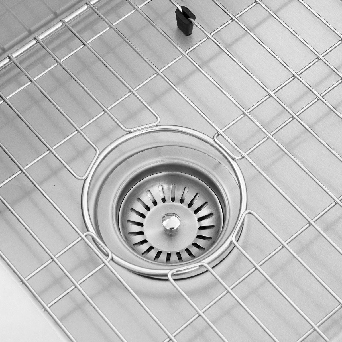 Stainless steel sink drain with strainer inside a matching bottom grid rack