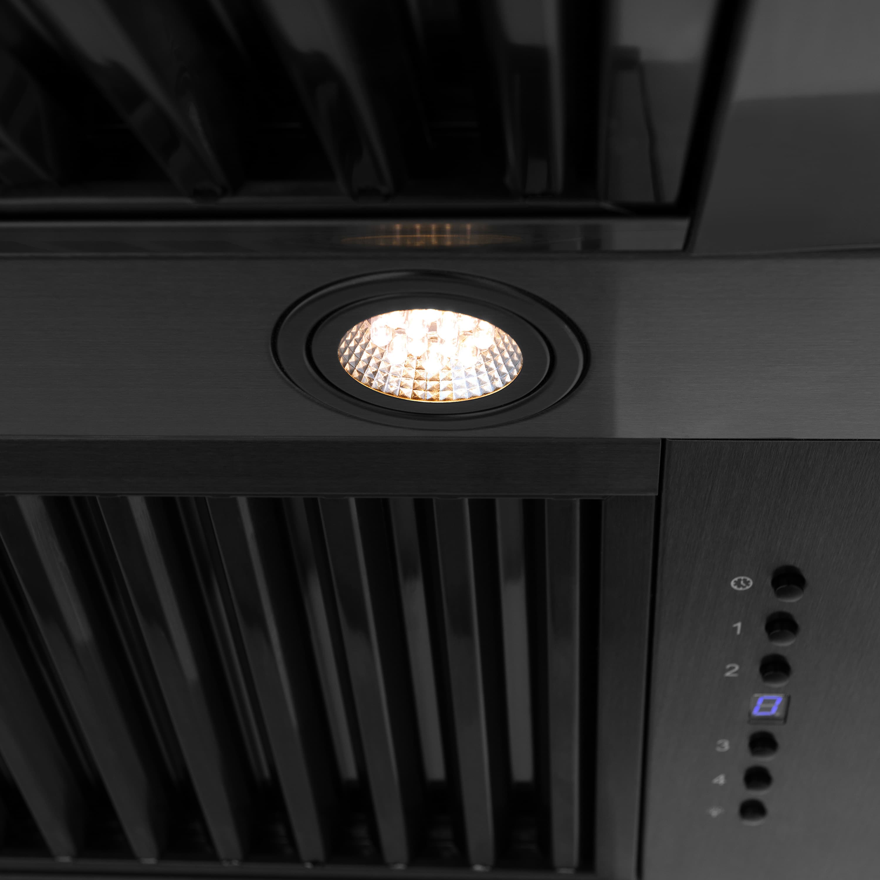 Black wall range hood close-up: circular LED light and control buttons on vent panel.
