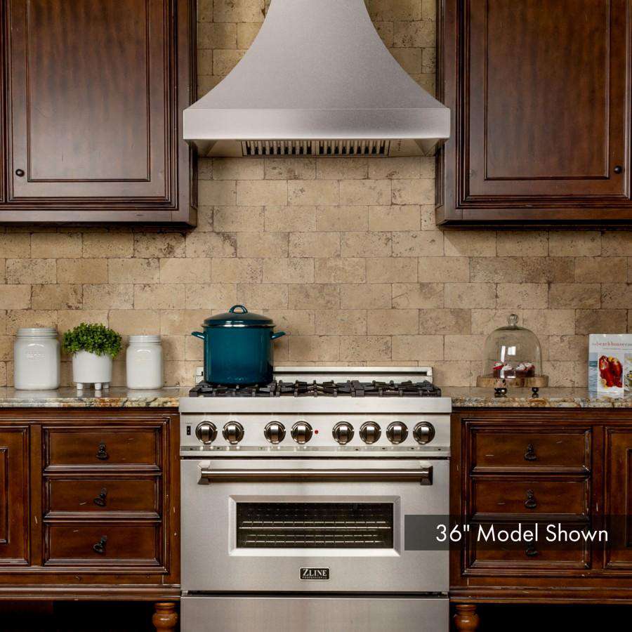 Satin stainless steel wall range hood above kitchen cooktop with vent chimney