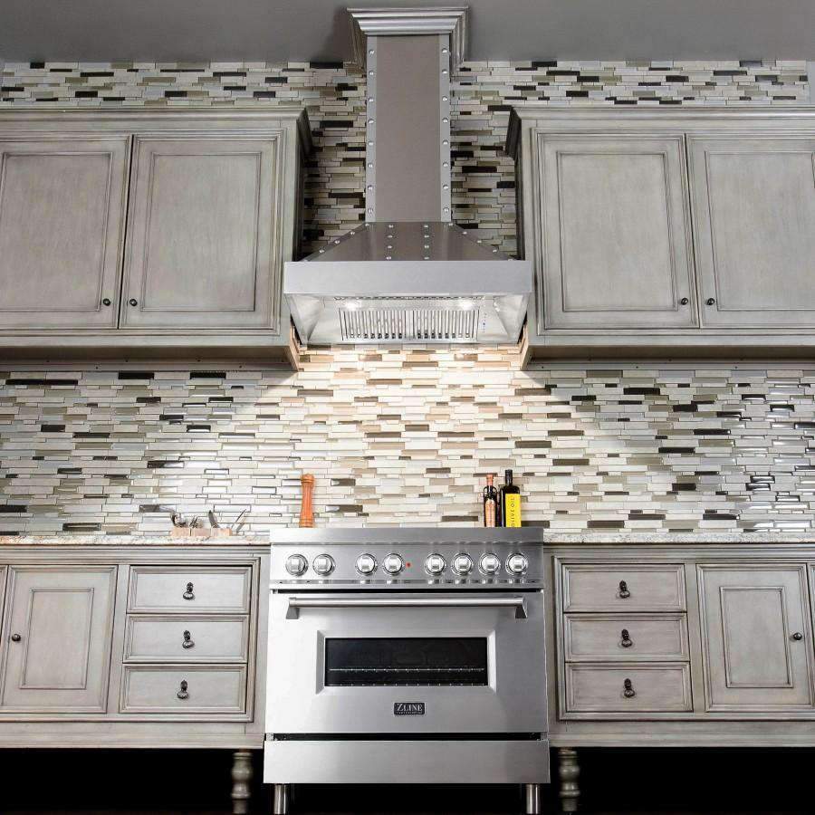 Stainless steel chimney wall range hood with vent opening above gas cooktop