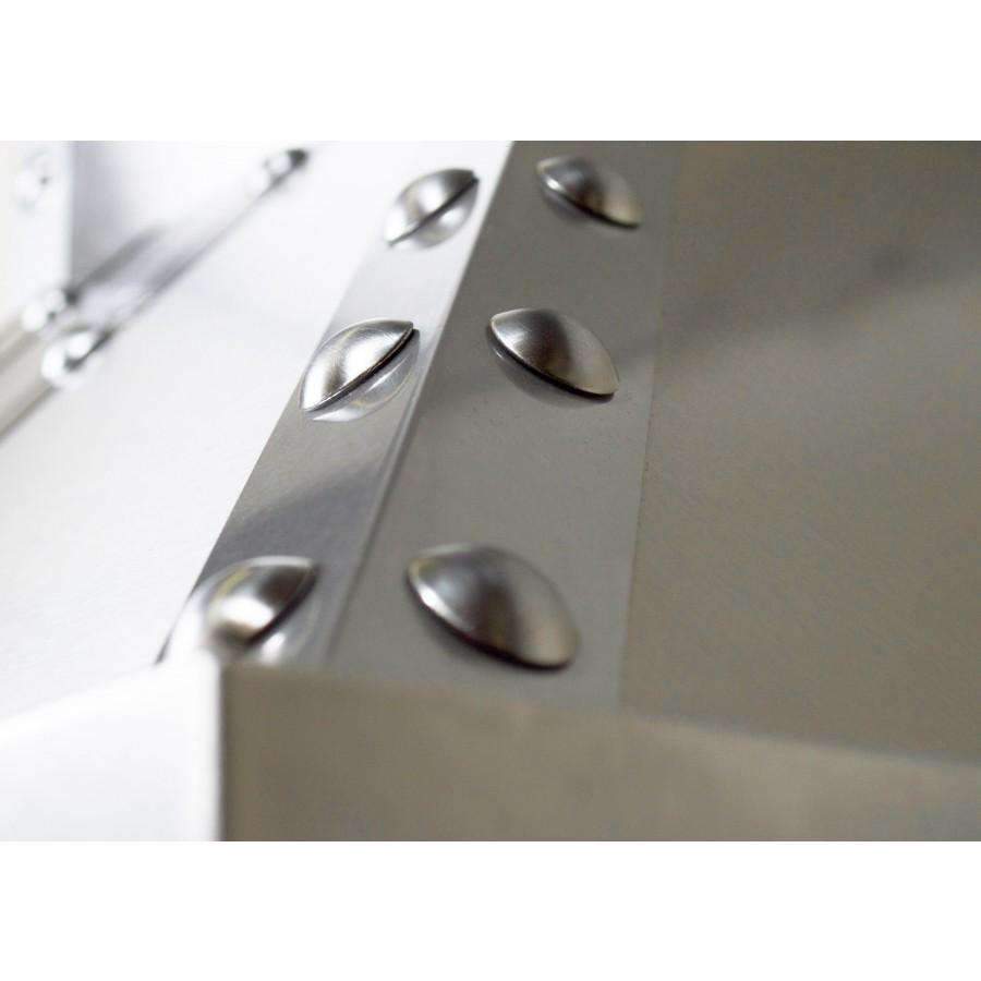 Close-up of stainless steel range hood baffle with circular vent holes