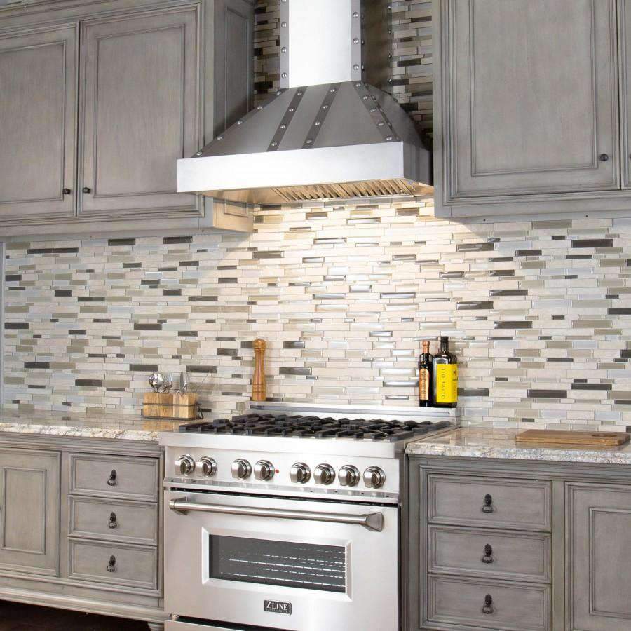 Stainless wall range hood above a black cooktop in a tiled kitchen