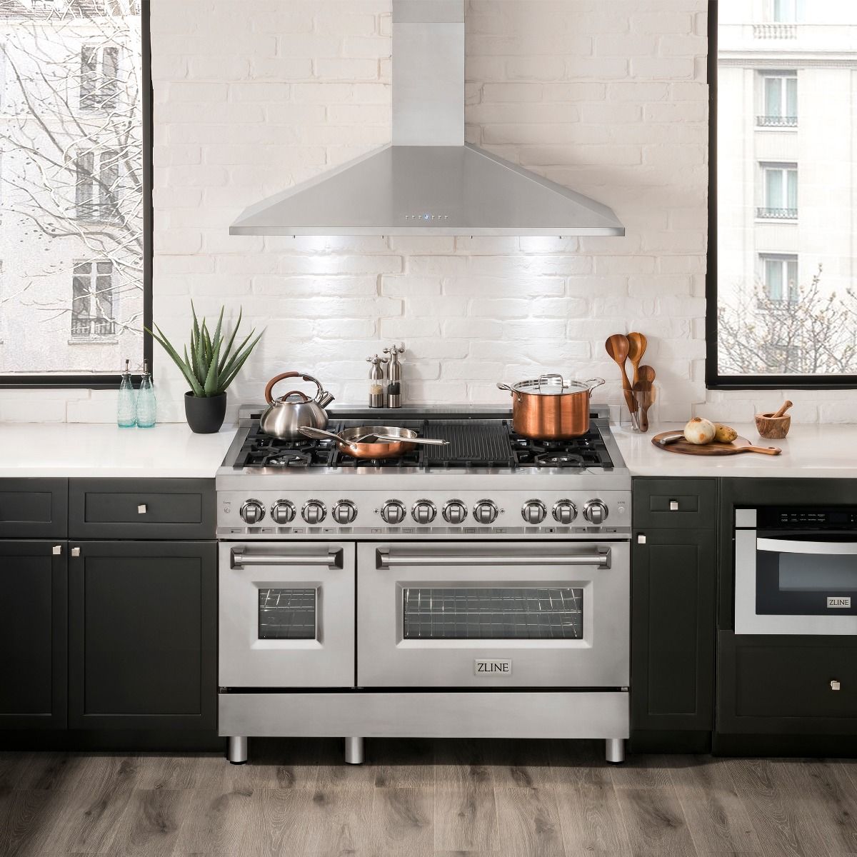 Stainless steel range hood over cooktop with tall chimney housing