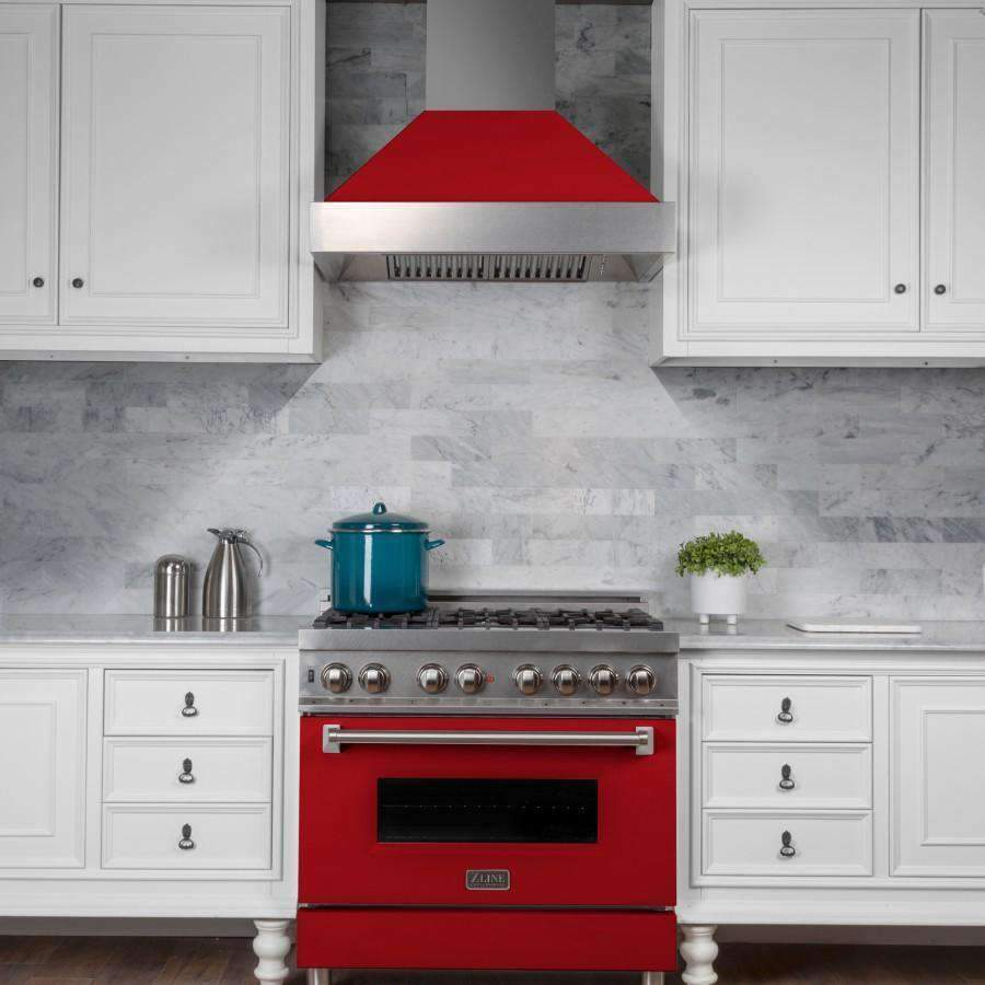 Ducted wall-mount range hood with red matte shell and stainless chimney above a gas range.