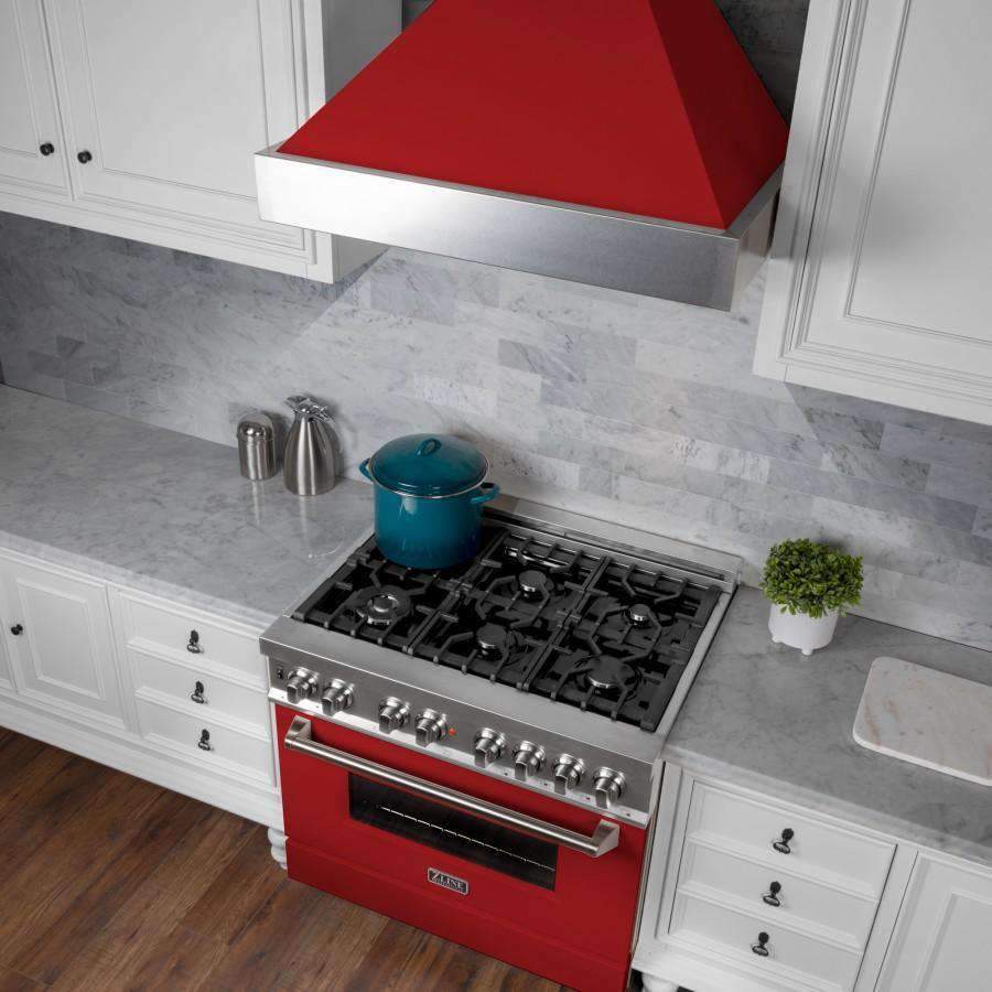 Red matte and stainless wall-mount range hood above a gas cooktop, with chimney chimney cover.