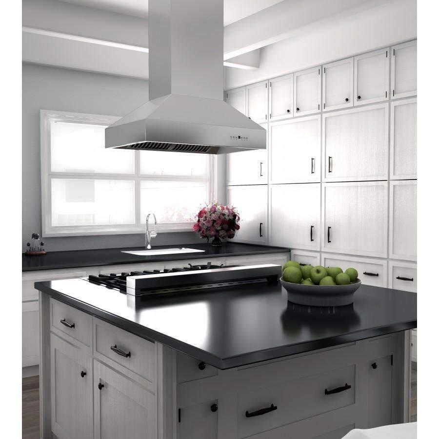 Stainless steel wall range hood over black cooktop with cabinetry and backsplash
