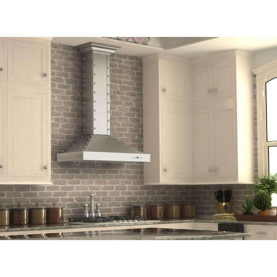 Stainless steel wall range hood mounted on brick backsplash