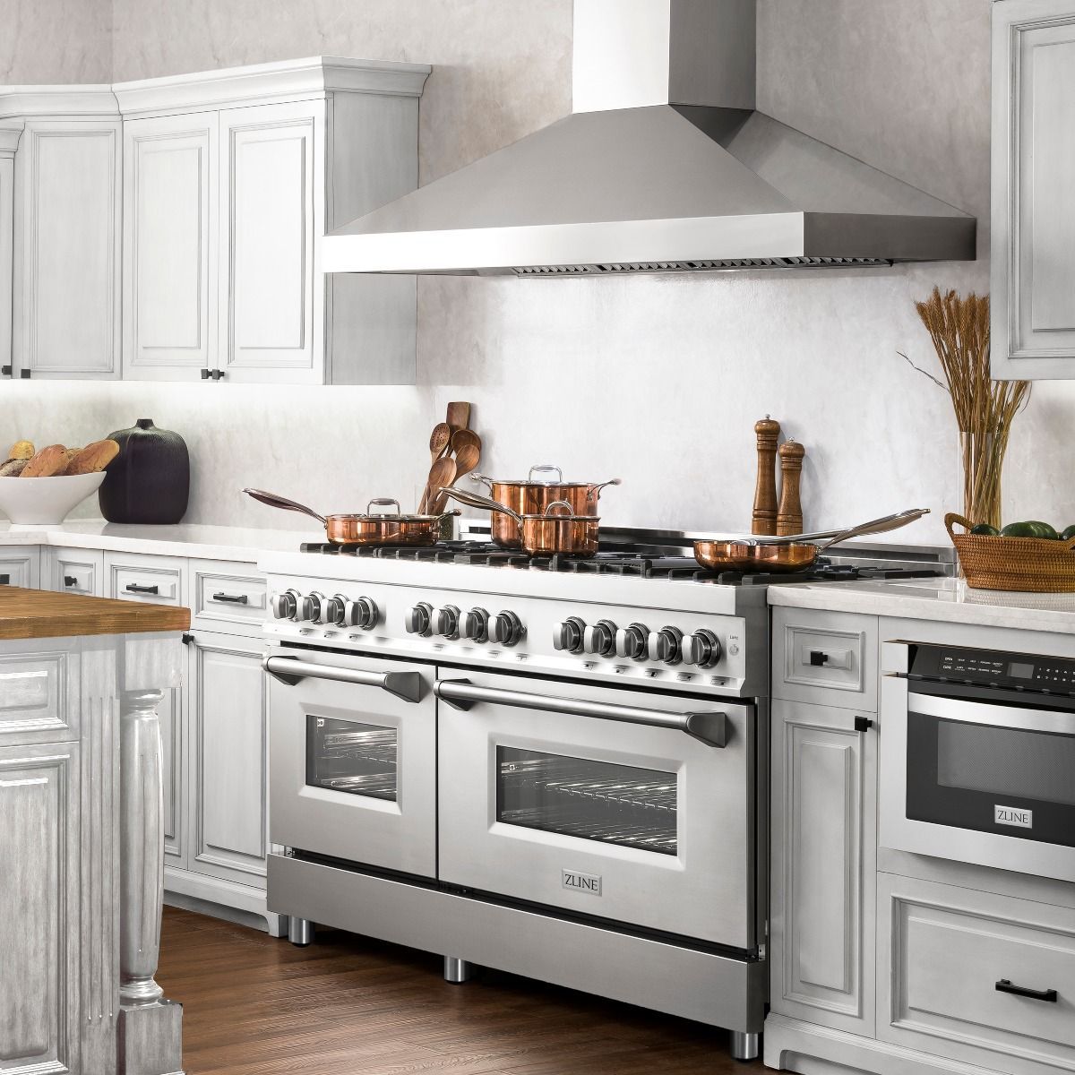 Stainless dual fuel range with oven doors, burner knobs, and chimney hood