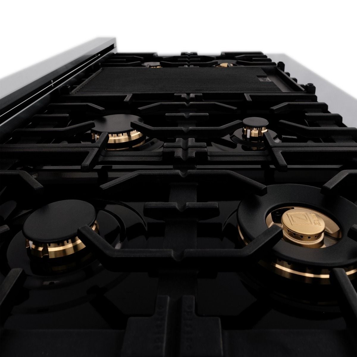 Black gas cooktop grate with brass burner heads and black burner rings