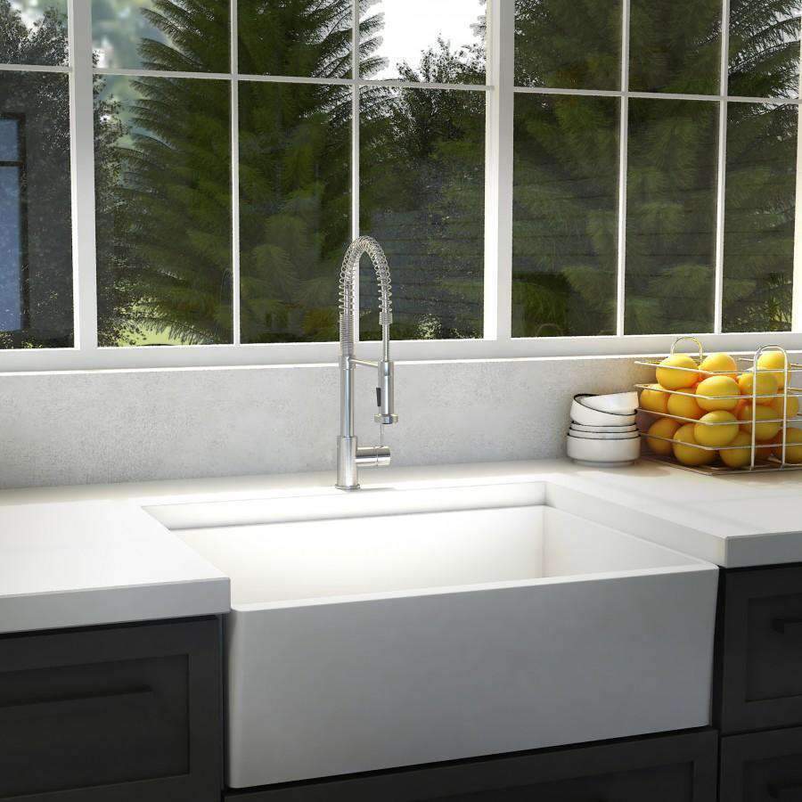 Chrome kitchen sink faucet centered over double basin with flexible spring sprayer