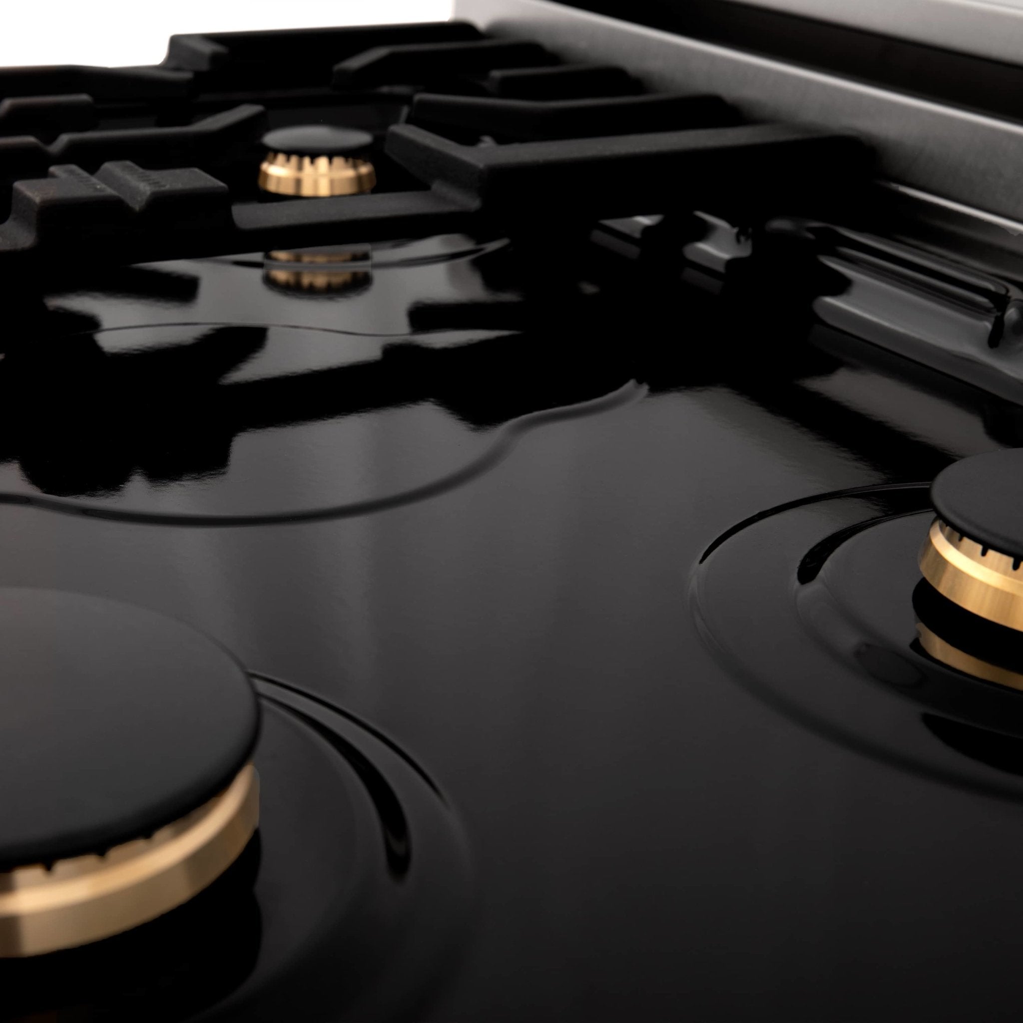 Dual fuel range cooktop with matte black grates and gold-trimmed burner caps