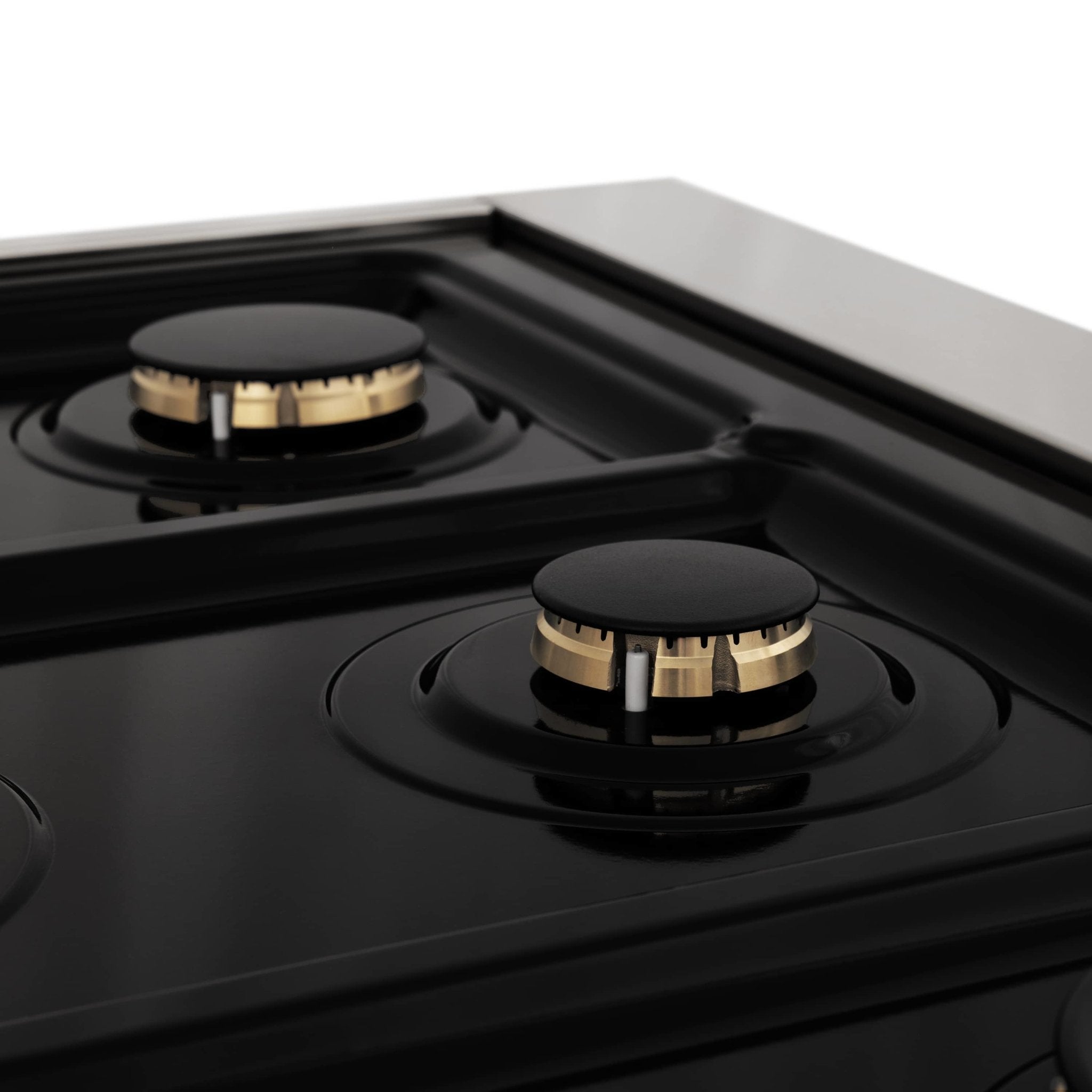 Black cooktop with two gas burner grates and brass burner caps