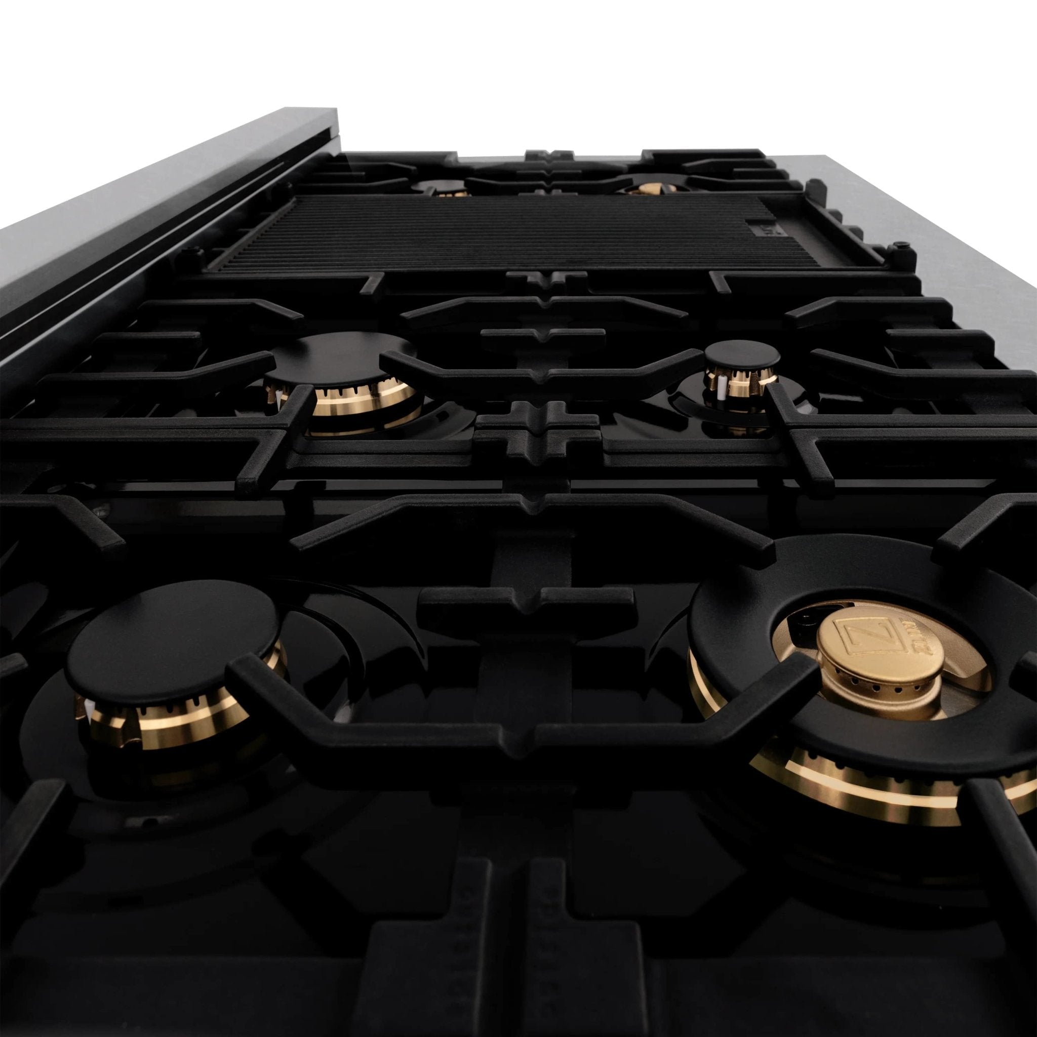 Black gas cooktop with four burners and gold caps