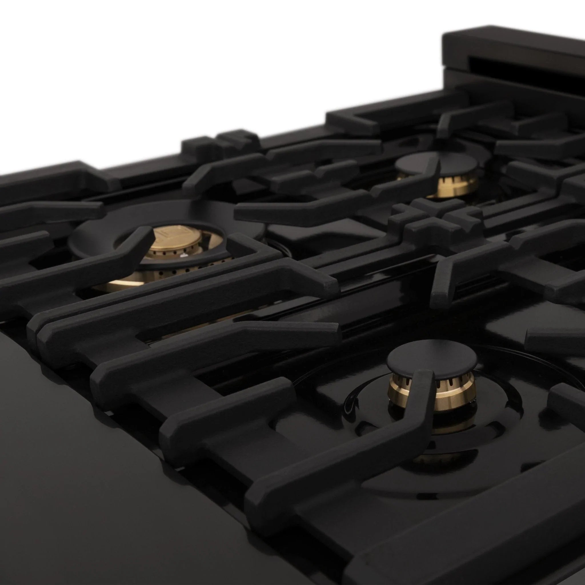 Close-up of black dual fuel range cooktop grates with gold burner caps
