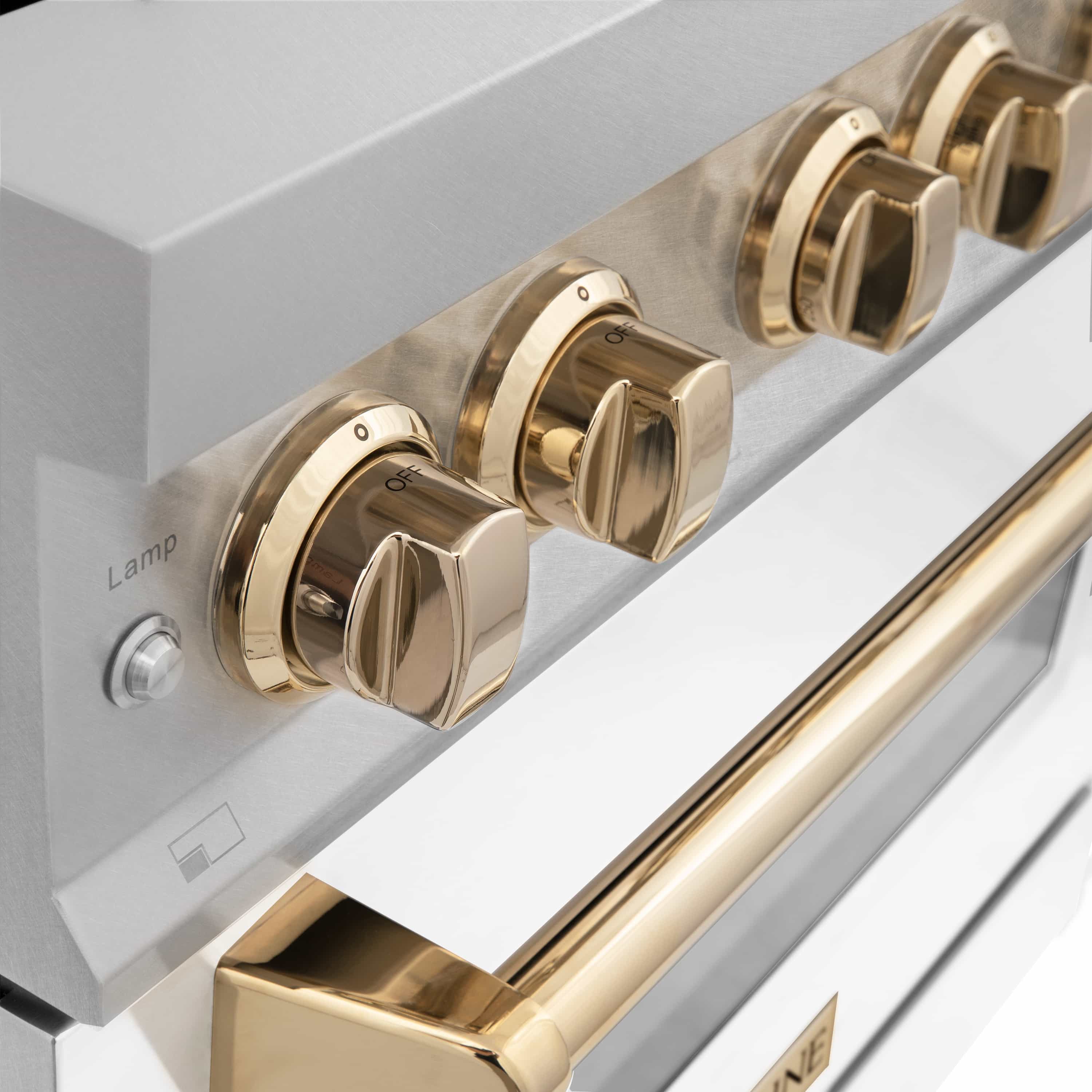 Close-up of gold control knobs and satin stainless control panel on a dual fuel range