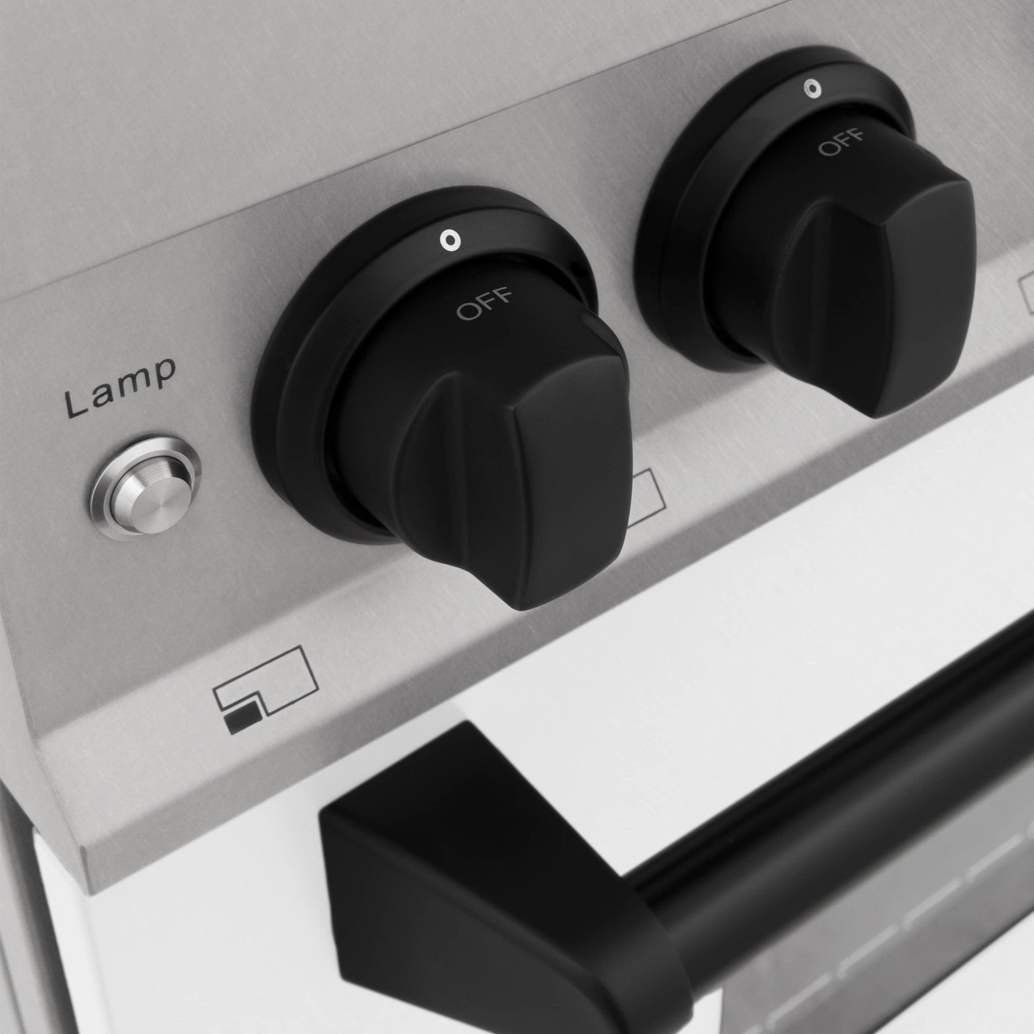 Dual fuel range oven control area with black temperature knobs and lamp switch