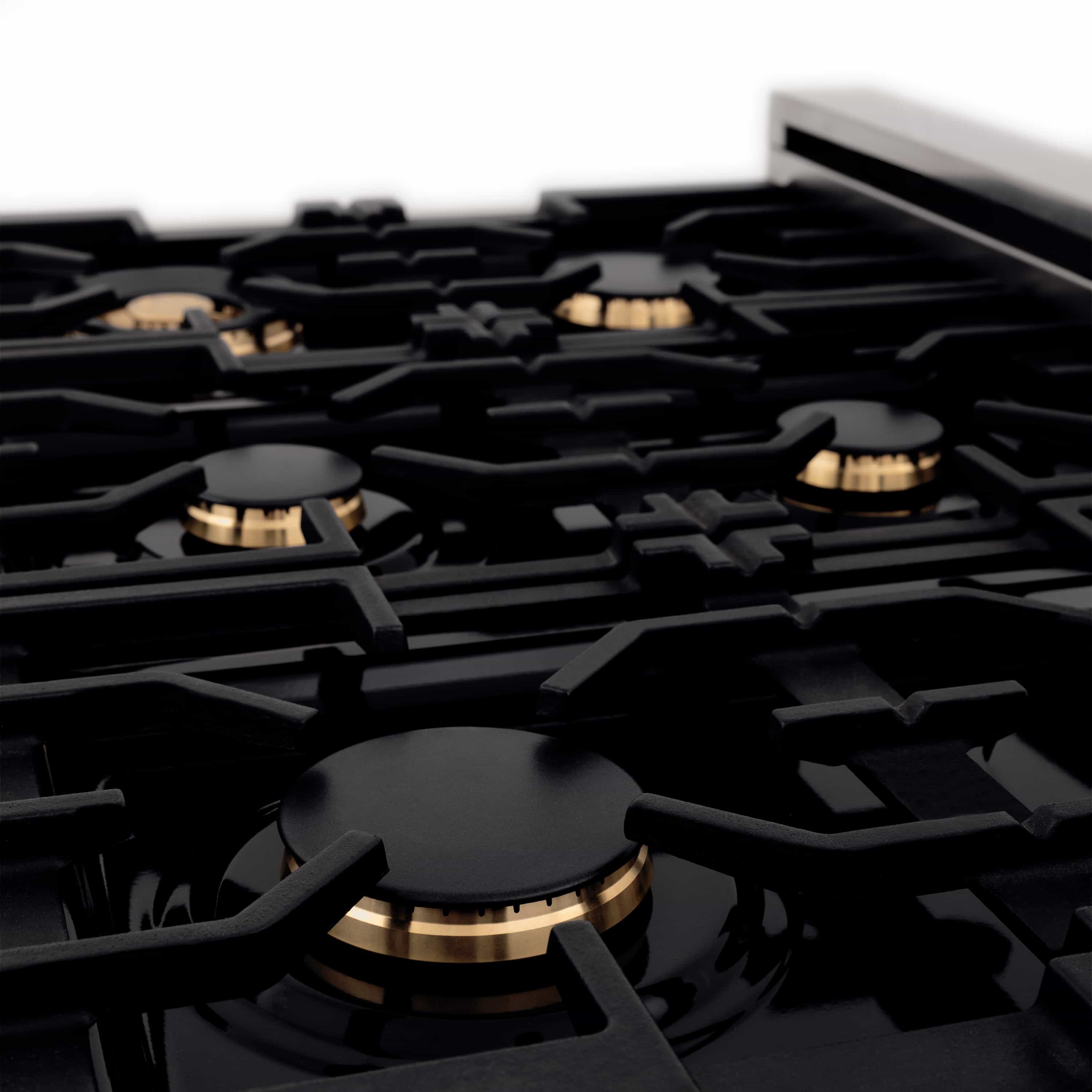 Black gas cooktop with multiple burners and gold-accented burner caps