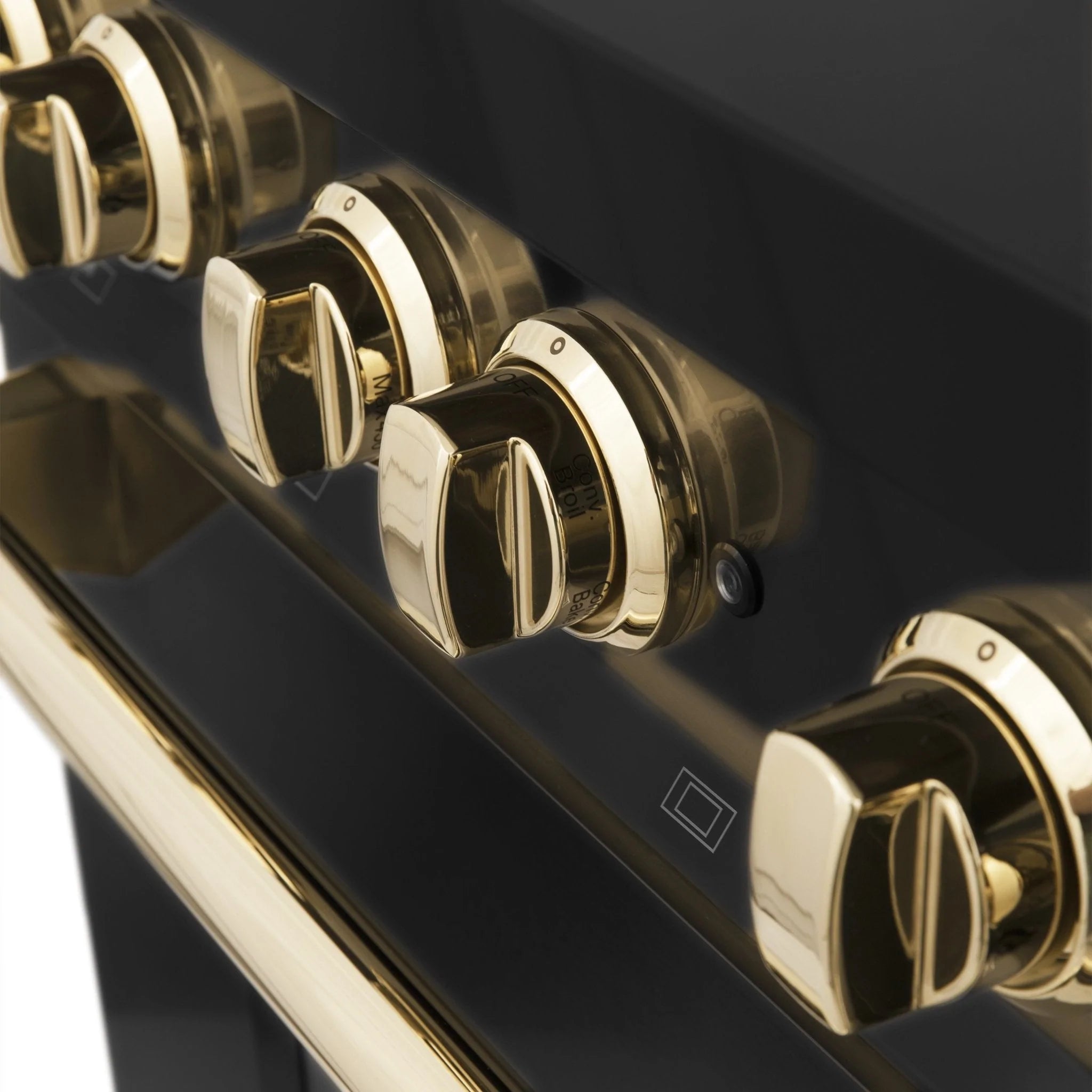 Gold-trim burner control knobs on a black range with small control icons.