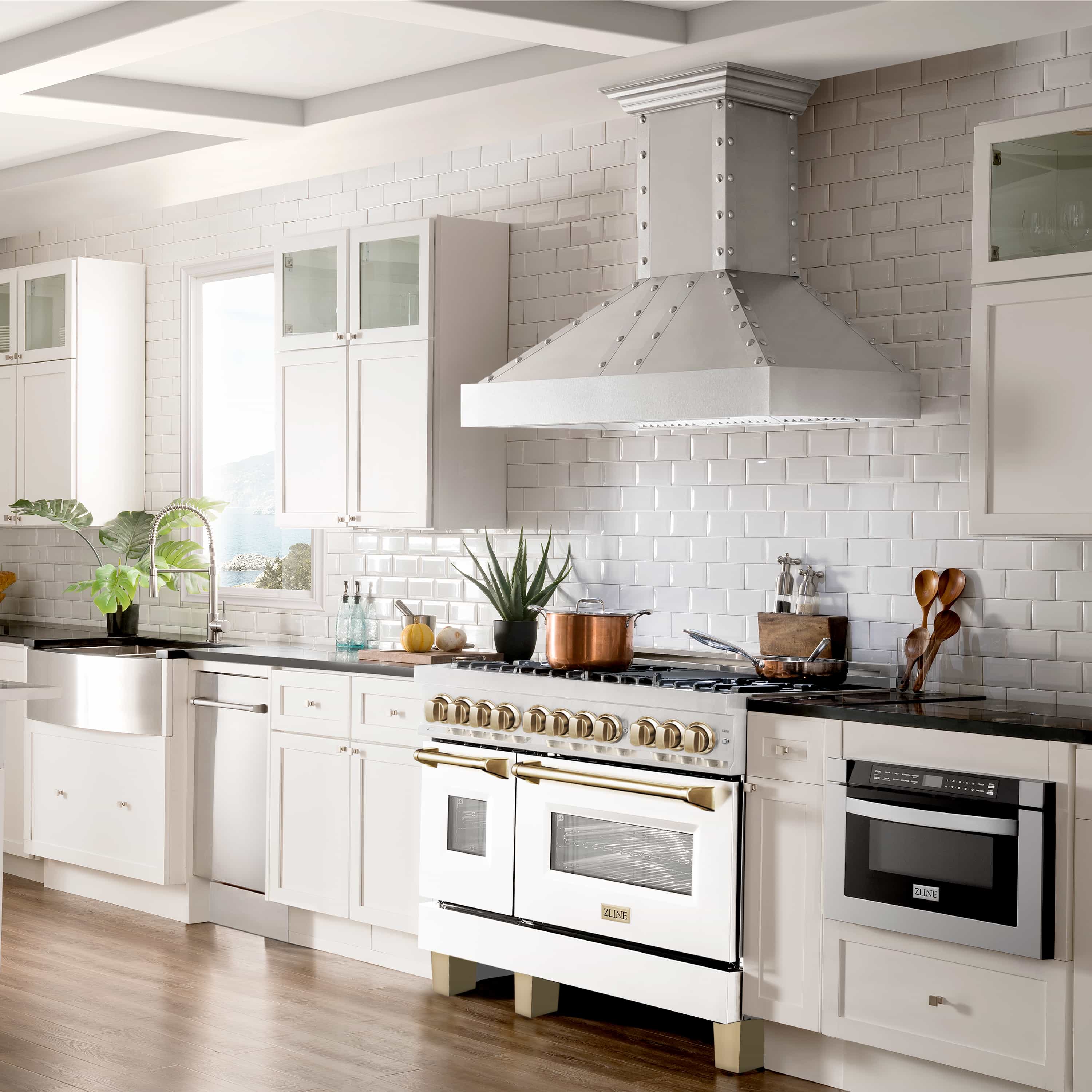 White dual fuel range with gold knobs, brass handles, and black oven doors
