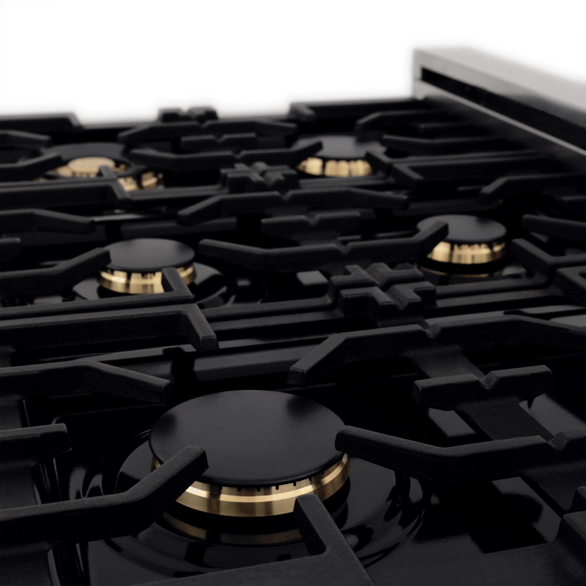 Dual fuel range cooktop with black burner grates and gold burner caps